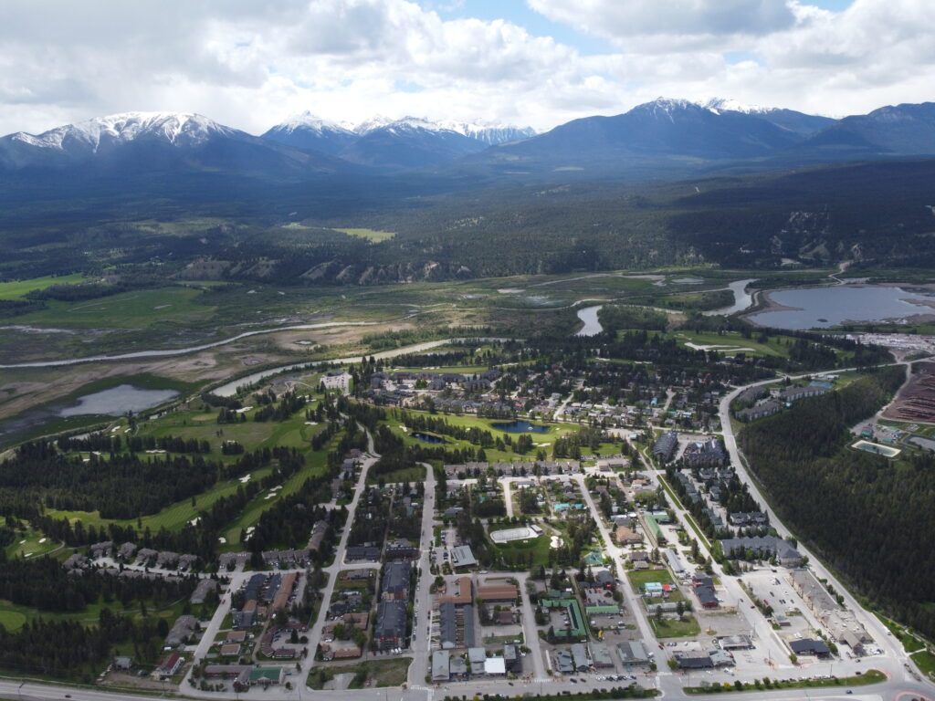 Ariel drone picture of town of Radium Hot Springs with mountains in the background.